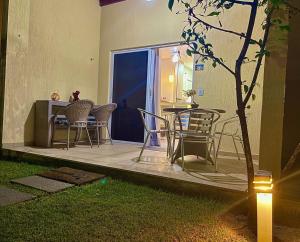 a patio with chairs and a table in a yard at Solar Água Duplex Top in Pipa