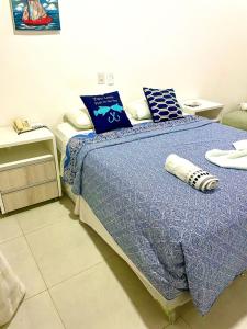 a bedroom with a bed with a blue blanket and pillows at Solar Água Duplex Top in Pipa