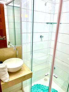 La salle de bains est pourvue d'un lavabo et d'une douche en verre. dans l'établissement Solar Água Duplex Top, à Pipa