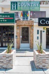 um edifício com dois plantadores de pedra à frente em Hotel Country Boutique em Piura