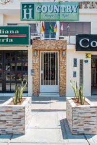 a building with two stone planters in front of it at Hotel Country Boutique in Piura