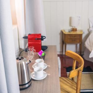 einem Holztisch mit zwei Tassen und einer Kaffeemaschine in der Unterkunft Bella Tilcara Boutique Hotel in Tilcara