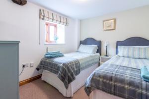 a bedroom with two beds and a window at The Chaff House - farm stay apartment set within 135 acres in Bromyard