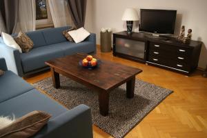 a living room with a blue couch and a coffee table at Apartament Daszyńskiego in Krakow