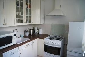 a kitchen with white cabinets and a stove top oven at Apartament Daszyńskiego in Krakow