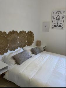 - une chambre avec un lit blanc et une tête de lit en bois dans l'établissement Villa Valley, à San Pietro in Bevagna