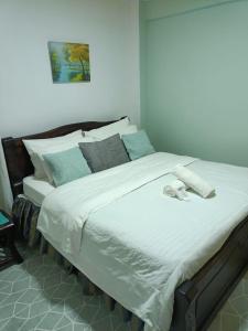 ein Schlafzimmer mit einem großen Bett mit weißer Bettwäsche und blauen Kissen in der Unterkunft Funstay Holiday Homes Nairobi 2 in Nairobi