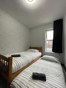two twin beds in a room with a window at Newly refurbished 3 bedroom entire terraced house in Lincolnshire