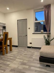 sala de estar con mesa, silla y puerta en Newly refurbished 3 bedroom entire terraced house, en Lincolnshire