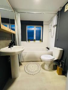 baño con lavabo y aseo y ventana en Newly refurbished 3 bedroom entire terraced house, en Lincolnshire
