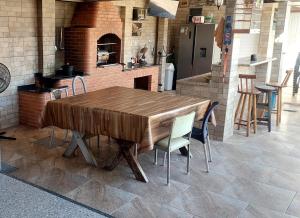 a wooden table and chairs in a kitchen at Hostel Falcão-Suites Privativas com Ar Condicionado in Rio das Ostras