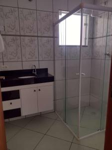 a bathroom with a glass shower and a sink at casa ana centro in Caraguatatuba