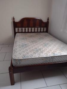 a bed in a room with a wooden frame at casa ana centro in Caraguatatuba