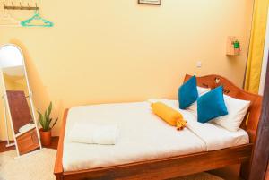 a bedroom with a bed with blue and yellow pillows at Naivasha Southlake apartments in Naivasha