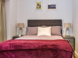 a bedroom with a large bed with a red blanket at Farthing in Epsom