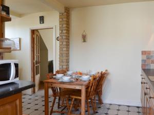 a kitchen with a table with chairs and a microwave at Meadow View in Dove Holes