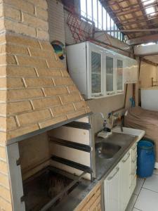 eine Küche mit Spüle und Ziegelwand in der Unterkunft Casa Praia Grande Mirim in Praia Grande + 8 Fotos