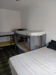 ein Tisch neben einem Bett in einem Zimmer in der Unterkunft Casa Praia Grande Mirim in Praia Grande