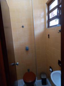 ein Badezimmer mit Dusche, Toilette und Waschbecken in der Unterkunft Casa Praia Grande Mirim in Praia Grande