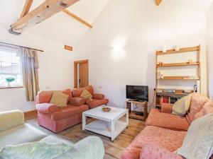 a living room with two couches and a tv at Leedale Cottage in Saltmarshe