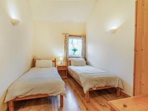 two beds in a room with a window at Leedale Cottage in Saltmarshe