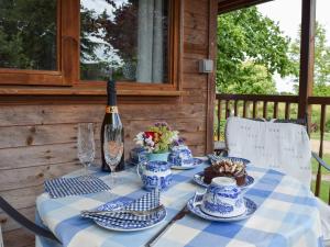 un tavolo con porcellana blu e bianca e una bottiglia di vino di Lakeside Cabin a Kingston Blount
