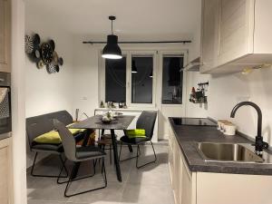 cocina con mesa, sillas y fregadero en Apartments Gozdni Raj Rogla, en Oplotnica