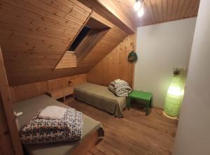 an attic room with two beds and a lamp at Western Tatras Slovakia in Oravský Biely Potok