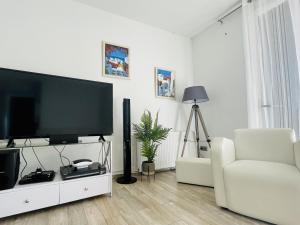 Villa loralil by costabravaway في كالونج: غرفة معيشة مع تلفزيون بشاشة مسطحة وأريكة بيضاء