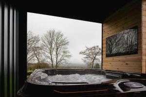 einen Whirlpool in einem Zimmer mit einem großen Fenster in der Unterkunft The Cosy Inn - Luxury Private Hot-Tub in Dungiven