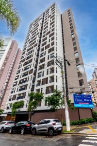 a tall white building with cars parked in front of it at 360 Klabin in Sao Paulo