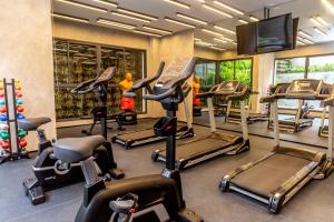 a gym with several cardio machines and a flat screen tv at 360 Klabin in Sao Paulo