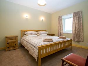 a bedroom with a large bed and a window at Sheaf Dale in Portmahomack