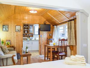Woodcarvers Cottage في Dawley: مطبخ وغرفة معيشة مع سرير وطاولة