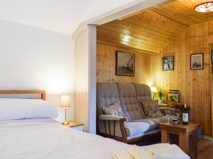 Woodcarvers Cottage في Dawley: غرفة نوم بسرير واريكة في غرفة