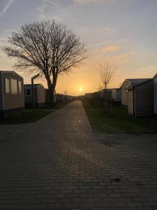 eine Backsteinstraße mit Sonnenuntergang im Hintergrund in der Unterkunft Oostkapelle Chalet JD 56 In de Bongerd in Oostkapelle