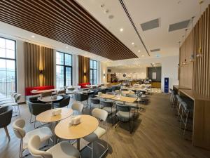 a restaurant with tables and chairs and windows at Holiday Inn Express - Ankara - Airport by IHG in Ankara