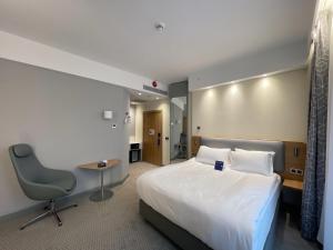 a hotel room with a bed and a desk and a chair at Holiday Inn Express - Ankara - Airport by IHG in Ankara