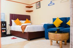 a bedroom with a bed and a blue couch at Nelly fully furnished studios in Naivasha
