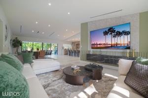 a living room with a couch and a tv on a wall at Luhos Paradise - Pickleball Extravaganza L07 in Miami