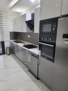 a kitchen with a stove and a microwave at MARINA APPART Hôtel in Dakar