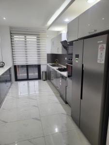 a kitchen with stainless steel appliances and a tile floor at MARINA APPART Hôtel in Dakar