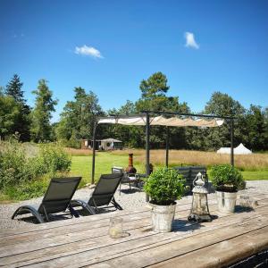 una mesa de madera con sillas y una sombrilla en Yurt at Le Ranch Camping et Glamping, en Madranges