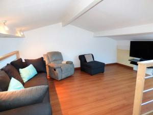 salon z kanapą, 2 krzesłami i telewizorem z płaskim ekranem w obiekcie *VILLA PALMA* 5 suites parentales, plage à 600 m, Vieux-Boucau w mieście Vieux-Boucau-les-Bains