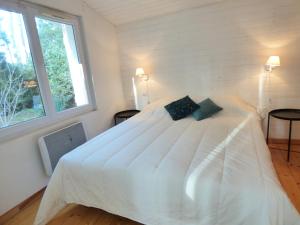białe łóżko w pokoju z oknem w obiekcie *VILLA PALMA* 5 suites parentales, plage à 600 m, Vieux-Boucau w mieście Vieux-Boucau-les-Bains +28 zdjęć