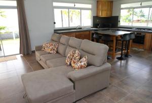 uma sala de estar com um sofá e uma cozinha em RAIATEA - Fare Te Hanatua em Tevaitoa