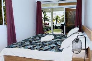 um quarto com uma cama grande e uma janela em RAIATEA - Fare Te Hanatua em Tevaitoa