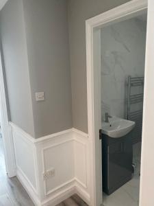 a white bathroom with a sink and a mirror at Modern house in Dublin in Dublin