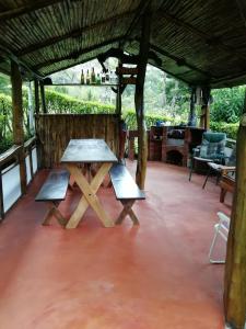 een picknicktafel op de veranda van een huis bij Pochote Lodge in Guayabos