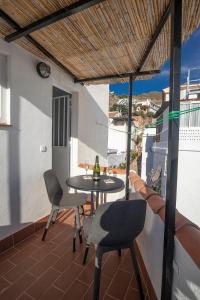 patio con mesa y sillas en el balcón en Casa Corbeto 7, en Cómpeta